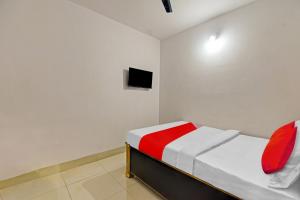 ein kleines Schlafzimmer mit einem Bett und einem TV in der Unterkunft OYO Flagship 81047 Hotel Dream Inn in Gamhāria