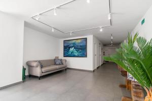卡塔赫纳Apartamento Unik Cartagena Edificio Faro Tequendama的客厅里有一张沙发，墙上挂着一幅画