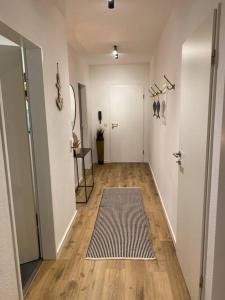 a hallway with white walls and wooden floors and a rug at “Heimathafen“ in Bad Zwischenahn in Bad Zwischenahn