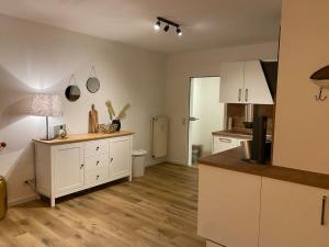 a kitchen with white cabinets and a wooden floor at “Heimathafen“ in Bad Zwischenahn in Bad Zwischenahn