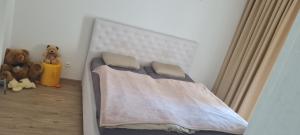 a bed in a bedroom with two teddy bears at Villa Senec Gardens in Senec
