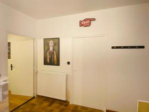 une chambre avec une porte blanche et un panneau sur le mur dans l'établissement La fermette: Logis indépendant proche d'Arras sur cours au carré, à Achicourt