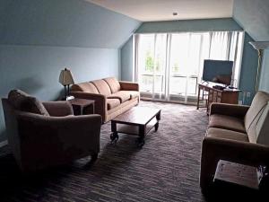 a living room with two couches and a tv at Sun Castle Resort in Lake George