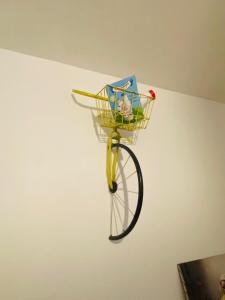 - un vélo avec un panier suspendu sur un mur dans l'établissement La fermette: Logis indépendant proche d'Arras sur cours au carré, à Achicourt