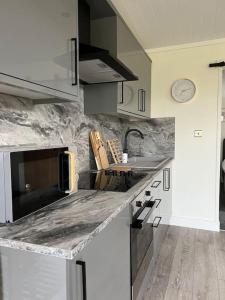 una cocina con fregadero y encimera en Island Coorie, en Kilmaluag 20 fotos más