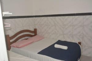 a small bed with pink and blue towels on it at Hostel Adriana Alves in Porto De Galinhas