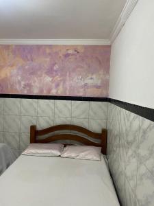 a bed in a room with a painting on the wall at Hostel Adriana Alves in Porto De Galinhas