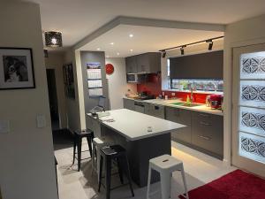 a kitchen with a counter and stools in it at Kaiapoi Village Deluxe Room with En-Suite Bathroom in Kaiapoi
