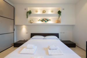 1 dormitorio con 1 cama blanca grande y 2 toallas en [IHost Apartment] - Tito Livio 20 en Milán