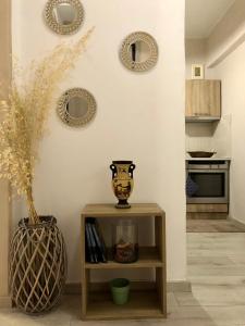 a room with a table with a vase and plates on the wall at The Acropolis Cave Apartment in Athens