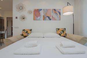 1 cama blanca con 2 sillas y 1 sofá en [IHost Apartment] - Tito Livio 20 en Milán