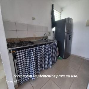 a kitchen with a stove and a refrigerator at HABITACION EN APARTAMENTO COMPARTIDO - VENTILADOR in Valledupar