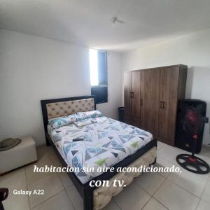a bedroom with a bed and a wooden cabinet at HABITACION EN APARTAMENTO COMPARTIDO - VENTILADOR in Valledupar