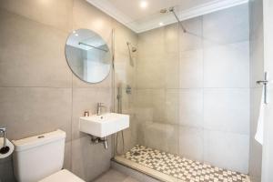 a bathroom with a toilet and a sink and a mirror at Spring Tide Inn by CTHA in Cape Town