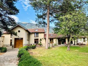 a house with a yard with trees in front of it at Подковите in Karlovo