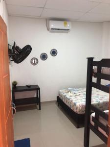 ein Schlafzimmer mit einem Bett und einem Ventilator an einer Wand in der Unterkunft Habitaciones Mónaco in Coveñas