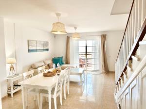 un soggiorno con tavolo e sedie bianchi di Sunny Beach Villa - El Medano a El Médano