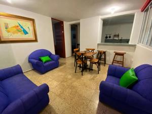 坎昆Departamento mercado 28, corazón de Cancún的客厅配有蓝色的沙发、桌子和椅子