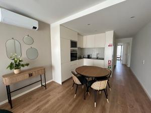 een keuken en eetkamer met een tafel en stoelen bij Leça Apartments in Leça da Palmeira