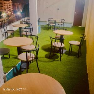 a room with tables and chairs with green grass at Store pyrmids view in Cairo