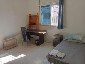 een slaapkamer met een bureau, een bed en een raam bij Maison indépendante 100m2 à Témara centre in Temara