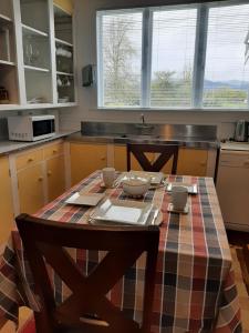 cocina con mesa con sillas y fregadero en Redwood en Hikutaia