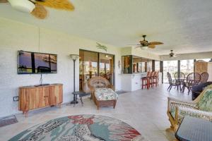 ein Wohnzimmer mit einem Sofa und einem TV in der Unterkunft Canalfront Cape Coral Home with Pool and Dock! in Cape Coral
