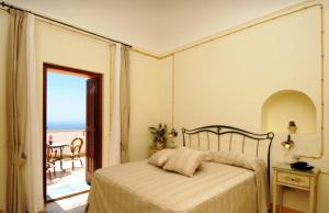 a bedroom with a bed and a view of the ocean at Locanda Degli Dei in Praiano