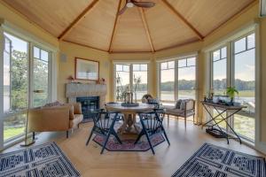 a living room with a table and chairs and windows at Luxe Scituate Vacation Rental with Private Hot Tub! in Scituate