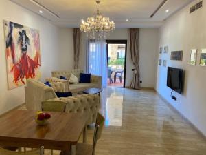 a living room with a table and a chandelier at Marchica Med atalayon in Nador