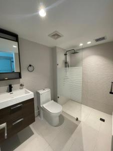 a bathroom with a toilet and a sink and a shower at Villa Marbella by Potenza Rentals in Santo Domingo