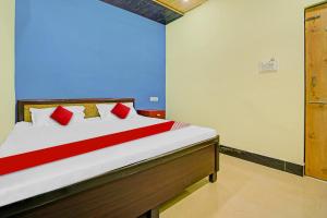 a bedroom with a bed with red pillows at OYO Flagship 81098 Hotel Uniq in Bhilai