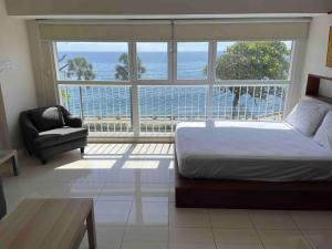 a bedroom with a bed and a view of the ocean at Villa Marbella by Potenza Rentals in Santo Domingo