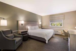 a hotel room with a bed and a chair at Best Western Sea Island Inn in Beaufort