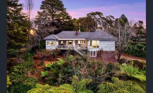 a white house in the middle of a garden at Blue Mountains Bliss in Leura