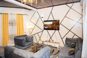 ein Wohnzimmer mit 2 Sofas und einem Flachbild-TV in der Unterkunft Hypo Guest Lounge in Jaunde