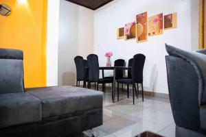 comedor con mesa y sillas negras en Hypo Guest Lounge, en Yaoundé