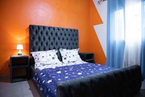 a bedroom with a bed with a blue comforter at Hypo Guest Lounge in Yaoundé