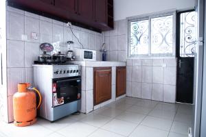 a small kitchen with a stove and a window at Hypo Guest Lounge in Yaoundé +8 photos