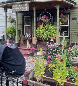 a dog sitting in front of a house with flowers at Downtown B&B with Jacuzzi in Glenwood Springs