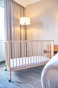a crib in a hotel room with a lamp at Radisson Blu Hotel Dortmund in Dortmund