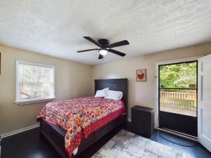 een slaapkamer met een bed en een plafondventilator bij Pine Forest Zen Cottage - 10 Min to Fort Bragg in Fayetteville