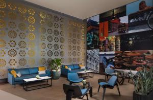 a lobby with blue couches and chairs and a wall at Radisson Hotel Colombo in Colombo