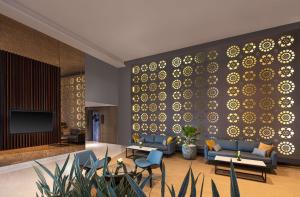 a lobby with couches and chairs and a wall at Radisson Hotel Colombo in Colombo