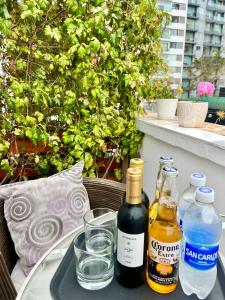 dos botellas de vino y vasos en una bandeja sobre una mesa en La Casa del Viajero, en Lima