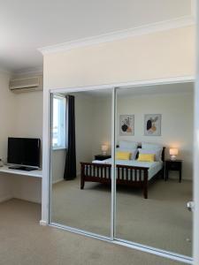 a bedroom with a bed and a mirror at 9/20 Apollo Quay Apartment in Mandurah