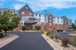 un hotel con aparcamiento frente a un edificio en MainStay Suites Fitchburg - Madison en Madison