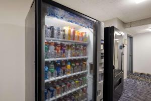 einem Kühlschrank mit vielen Flaschen Soda in der Unterkunft Suburban Studios Milwaukee Airport in Milwaukee