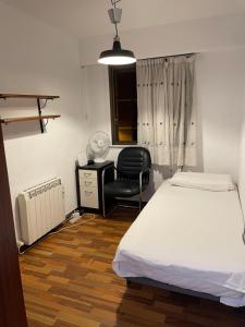 a bedroom with a bed and a desk and a chair at Como en casa in Barakaldo