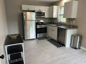 une cuisine avec des armoires blanches et des appareils en acier inoxydable dans l'établissement Oasis Of Maple Grove, à Maple Grove